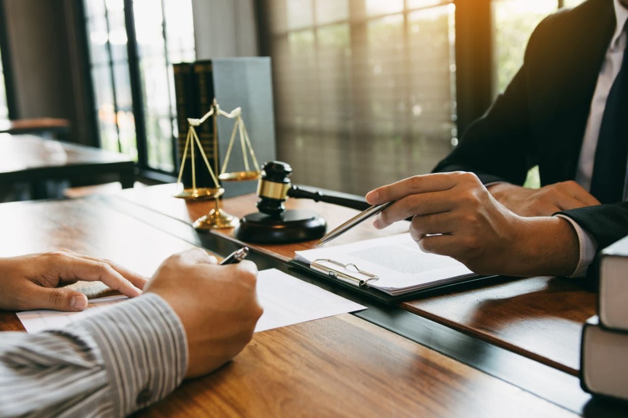 Two people discussing legal documents at a table.