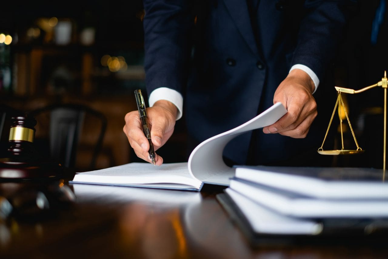 Person signing documents with a pen.